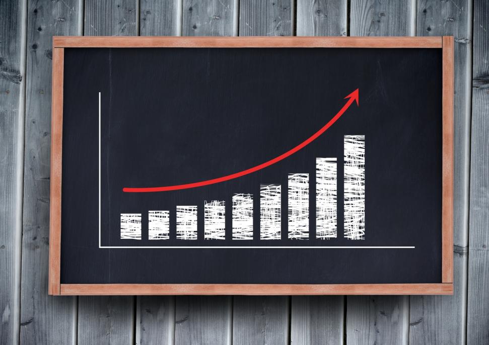 Digital composite of Chart scaling up drawing on a blackboard.